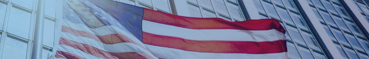 American flag flying against a tall building.