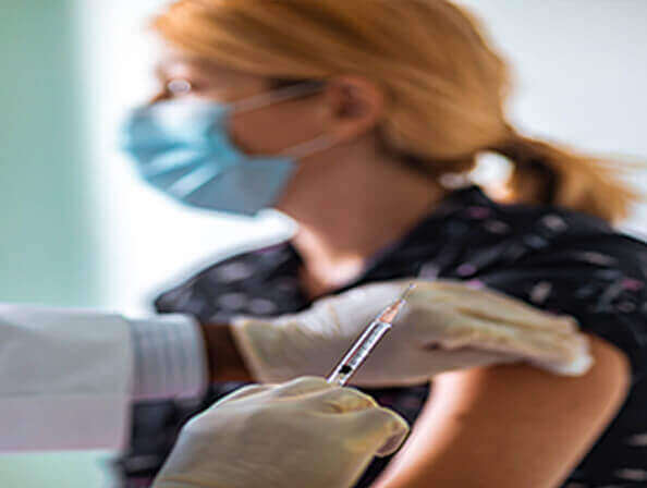 A medical practioner gives a patient a COVID vaccination. 