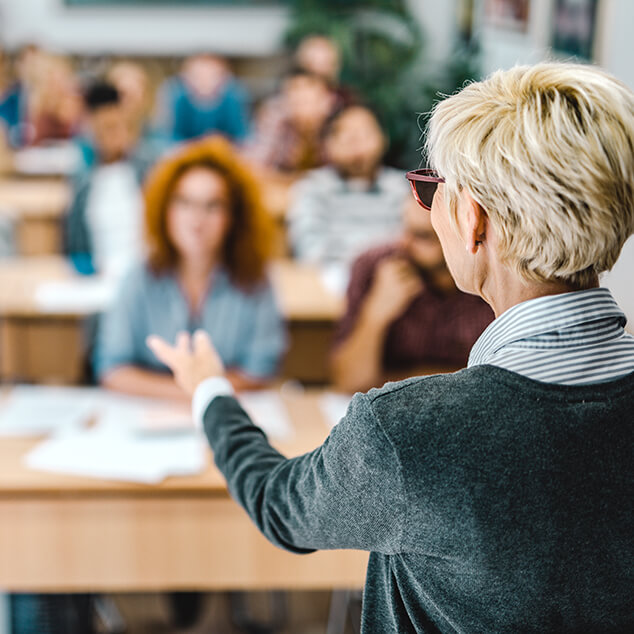 A female speaking to a university class of students. 