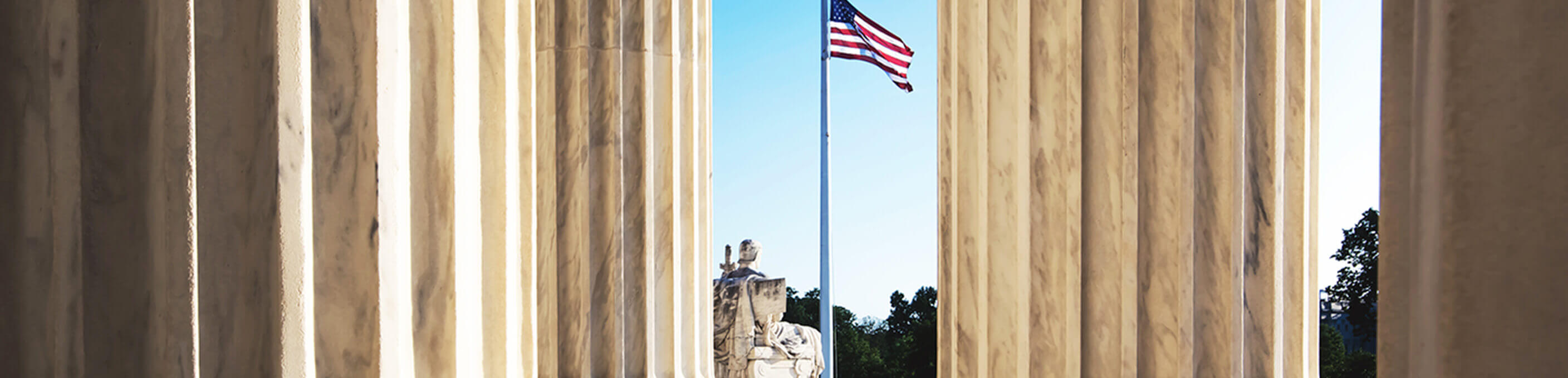 Washington DC monument with an American flag in the distance.