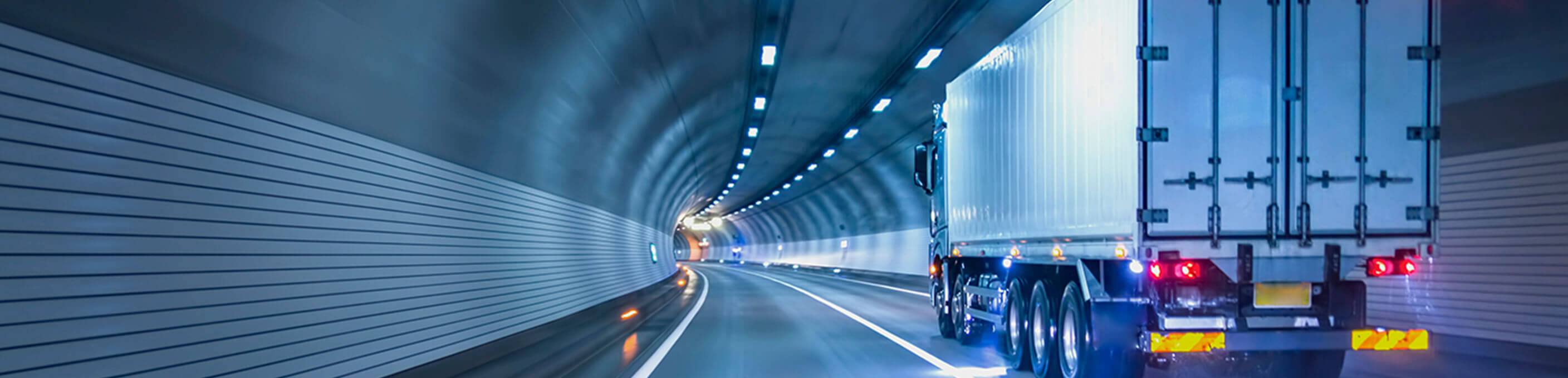 An 18-wheeler truck transporting cargo through a road tunnel. 
