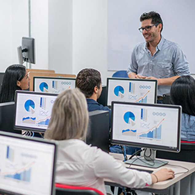 Professor teching in a classroom with computers