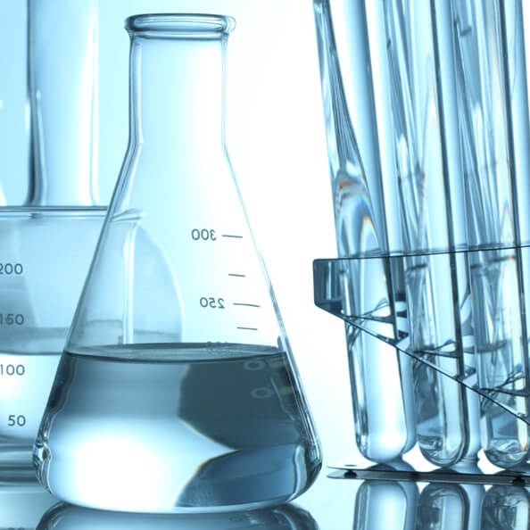 Light-blue tinted glass test tubes and beakers containing clear liquids. 