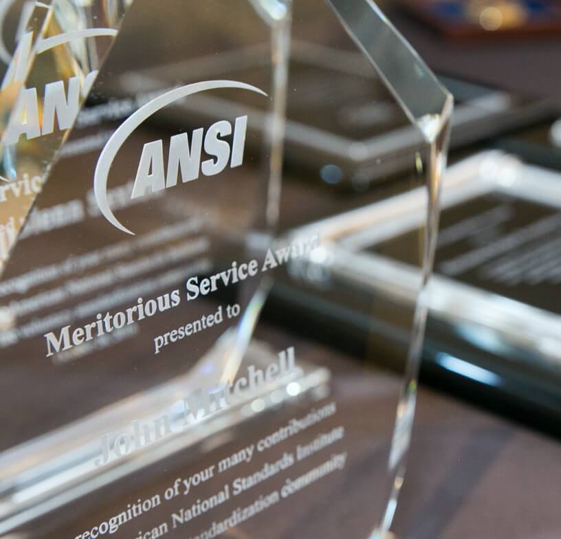 A clear glass crystal engraved for ANSI's Meritorious Service Award. 