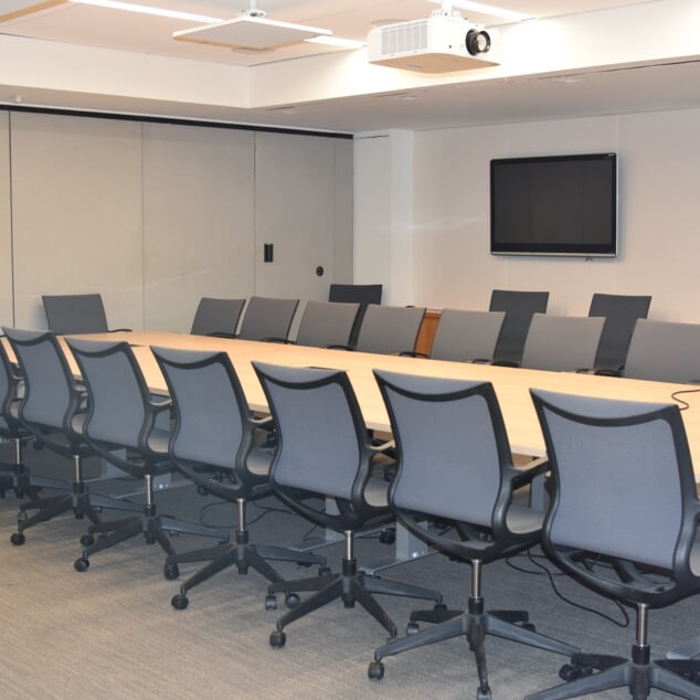 Numerous chairs at a table in a boardroom. 