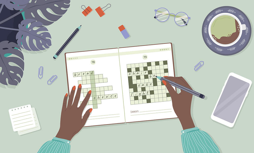 A person's hands doing a crossword puzzle