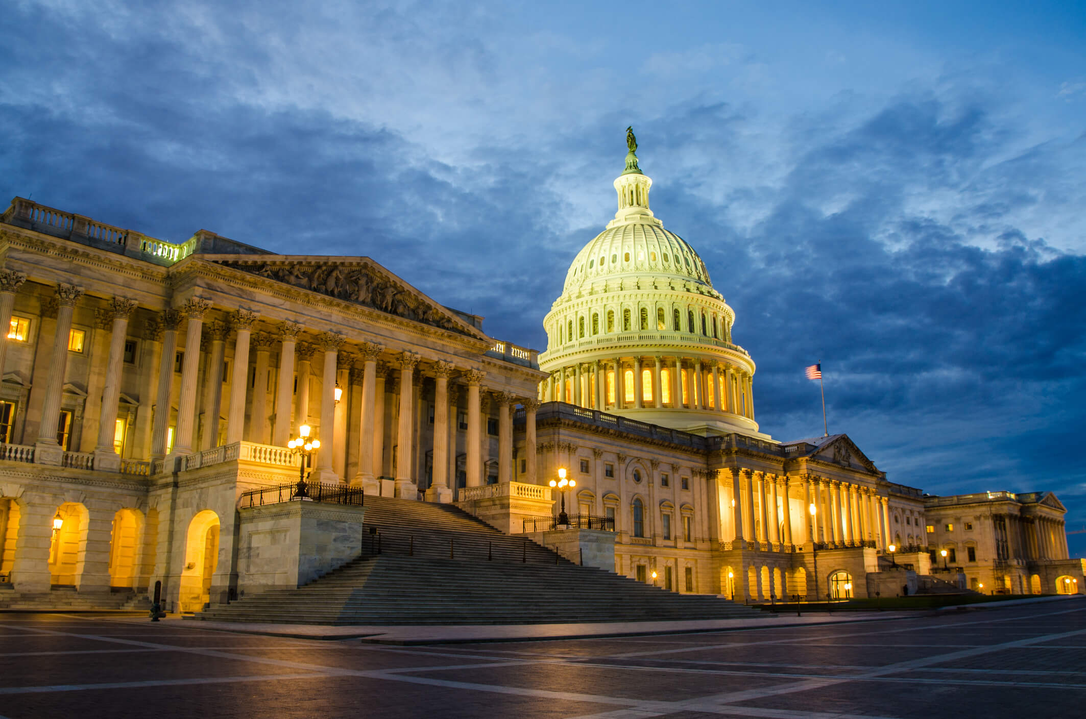 U.S. Capitol Building with a colorful sunset behind.